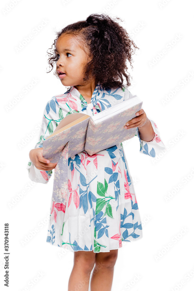 Little cute fashionable african american girl in white floral dress holding a notebook Little cute fashionable african american girl in white floral dress holding a notebook