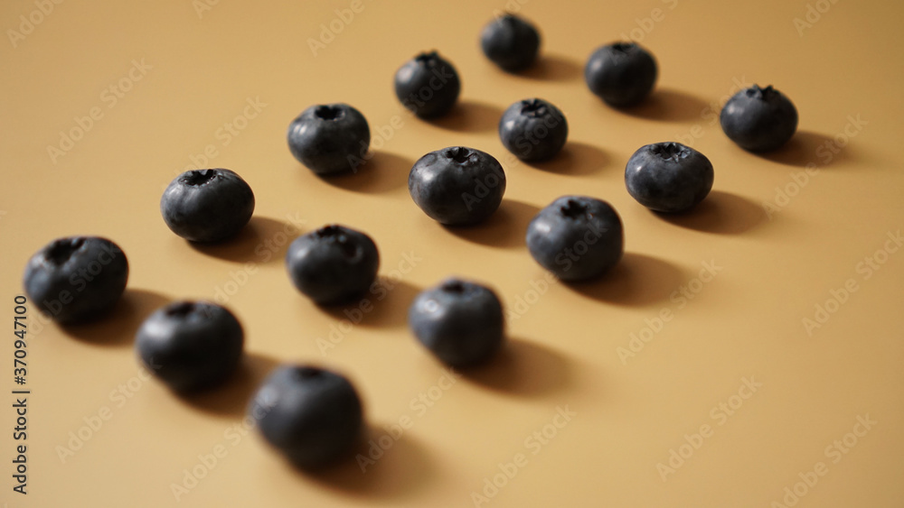Blueberries are laid out in rows on a gold background - perfectionism concept Blueberries are laid out in rows on a gold background - perfectionism concept