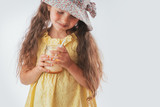 Beautiful little girl eating tasty cream dessert portrait isolated on white background