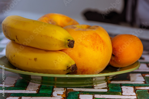 still life with natural and fresh seasonal fruits on a green plate photo