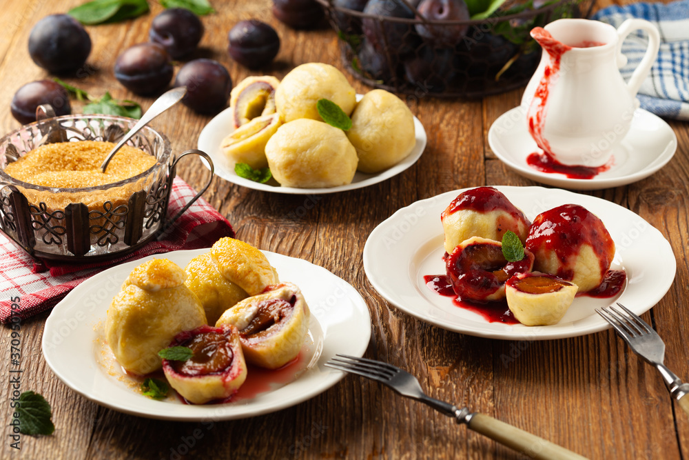 Dumplings with plums, topped with plum sauce or served with cream and sugar. Dumplings with plums, topped with plum sauce or served with cream and sugar.