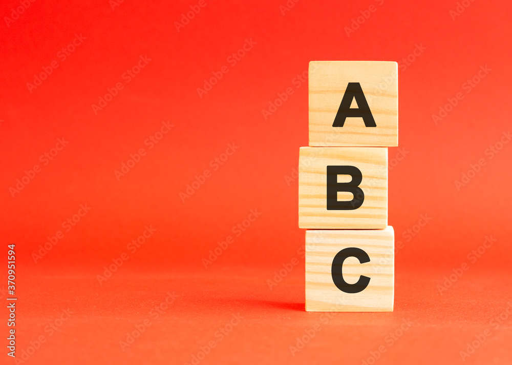 Wooden cubes with letters. For your design, concept. Wooden cubes on a red background. Free space on the left. Wooden cubes with letters. For your design, concept. Wooden cubes on a red background. Free space on the left.