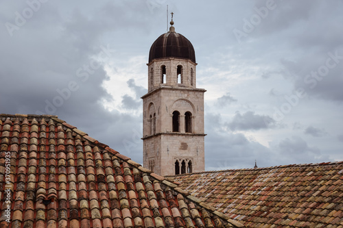 Obraz na płótnie church tower and clay tile roofs against the sky w salonie