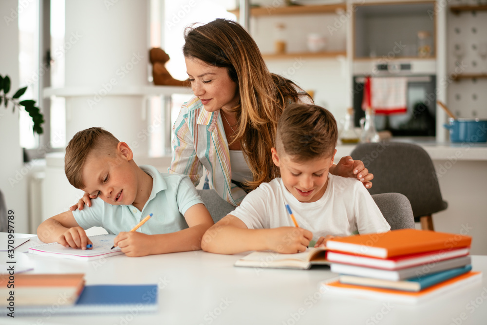 Mother helping her sons with homework at home. Little boys learning at home.. Mother helping her sons with homework at home. Little boys learning at home..