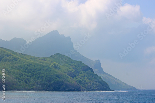 Big rock on Fiji island, with beach on the side, and hill on the back