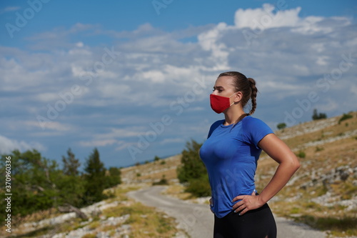 woman with protective mask relaxing after running