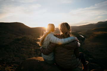 Mother and Daughter enjoying the view after a mountain hike during sunset