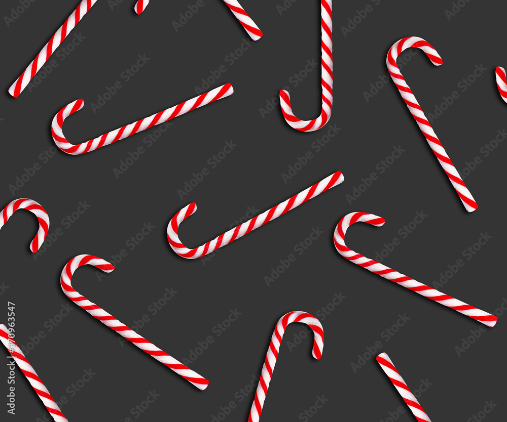 Pattern of Christmas candy canes on dark grey background, top view Pattern of Christmas candy canes on dark grey background, top view