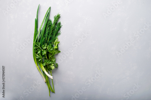 bunch of fresh herbs onions parsley and dill on an empty background