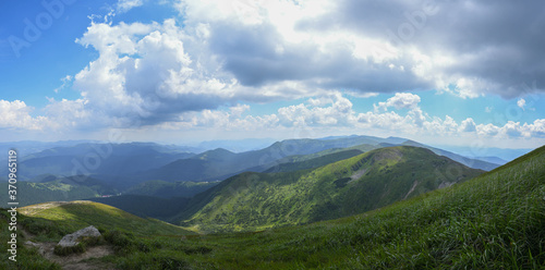 Panorama of the Carpathian mountains. Hoverla peak on a sunny day with blue sky and white clouds