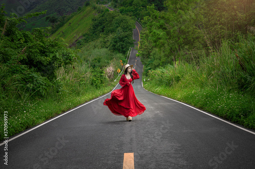 Asian woman walking on Beautiful sky road over the top of mountain and green forest in Pua, Nan, Thailand. photo