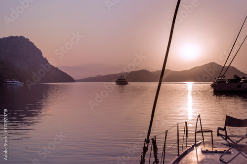 yacht charter and safe travel concept: morning dawn on sail boat