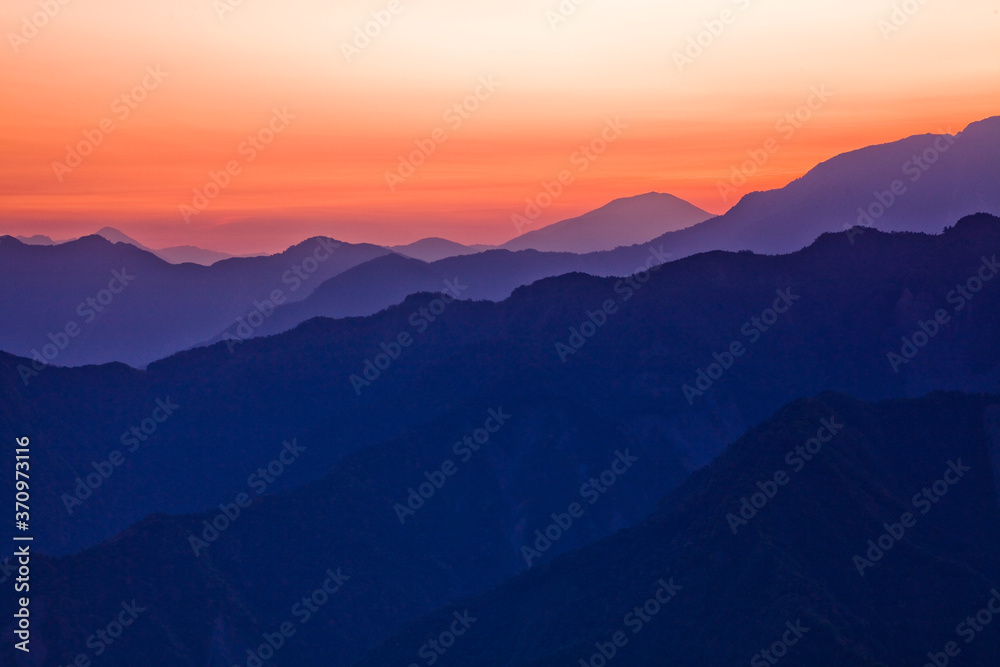 Layers of magnificent mountains with colorful clouds background at sunrise view