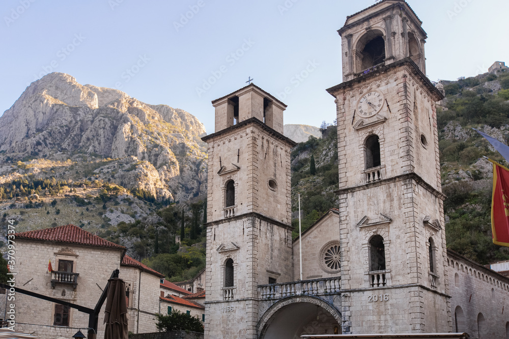 Medieval church with towers in Kotor (Montenegro) in mountains. Architectural decorations of buildings- columns, tops, gypsum stucco molding.
