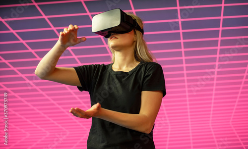 junge Frau mit VR - Brille steht vor Gitternetz