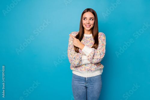 Photo of attractive cheerful lady good mood direct index finger side empty space advising banner sale information wear casual sweater denim jeans isolated blue color background © deagreez