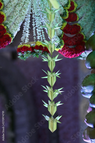 Plam leaf flower decorations are hanging in wedding 
 hall entrance photo