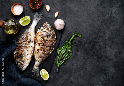 grilled dorado fish with ingredients on stone background with copy space for your text