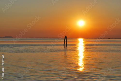 sunset on the Venetian lagoon with sun reflection on the water © arch.miola