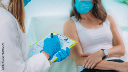 Nurse with Protective Mask Filling in Information Form. Blood Drawing and Analysis During Covid19 Coronavirus Crisis