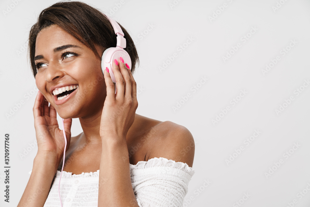 Image of joyful african american woman laughing and using headphones Image of joyful african american woman laughing and using headphones