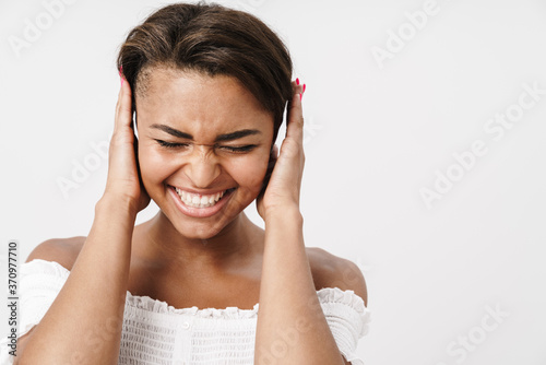 Image of joyful african american woman laughing and covering her ears