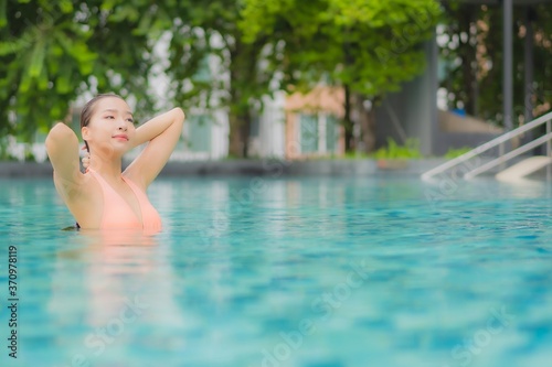 Portrait beautiful young asian woman relax smile leisure around outdoor swimming pool © siraphol