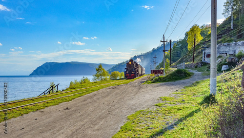 locomotive moves along the railway around lake Baikal photo