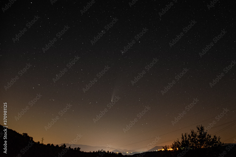 Fototapeta premium night sky with stars and neowise comet with a landscape