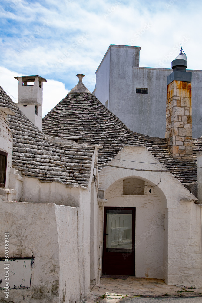 alberobello with blue sky  in background and the trulli in foreground