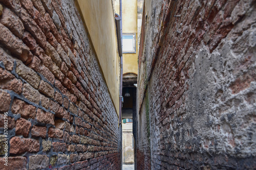 narrow passage between old brick walls in Venice © Focusima
