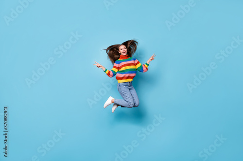 Full length body size view of her she nice-looking attractive careless funky cheerful cheery girl jumping having fun showing v-sign free time party isolated blue pastel color background
