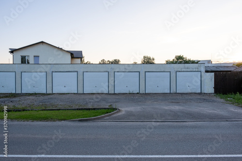 Fototapeta Naklejka Na Ścianę i Meble -  garage row at sunset with white automatic doors