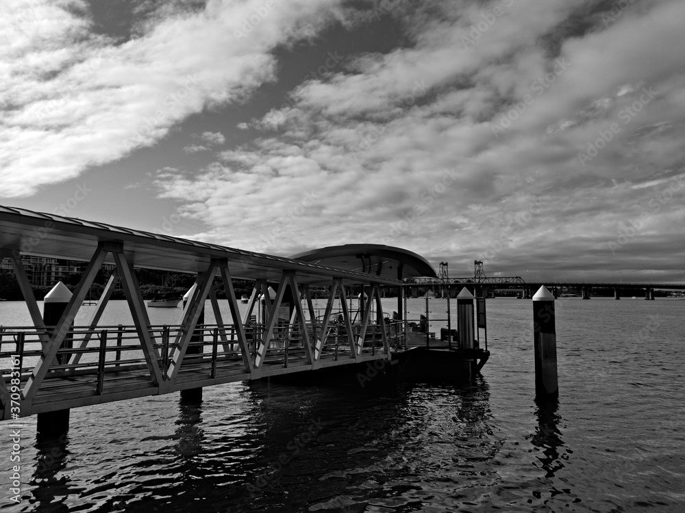 Beautiful black and white view of a wharf along a river on a sunny day with clouds, Parramatta river, Meadowbank, Sydney, New South Wales, Australia
