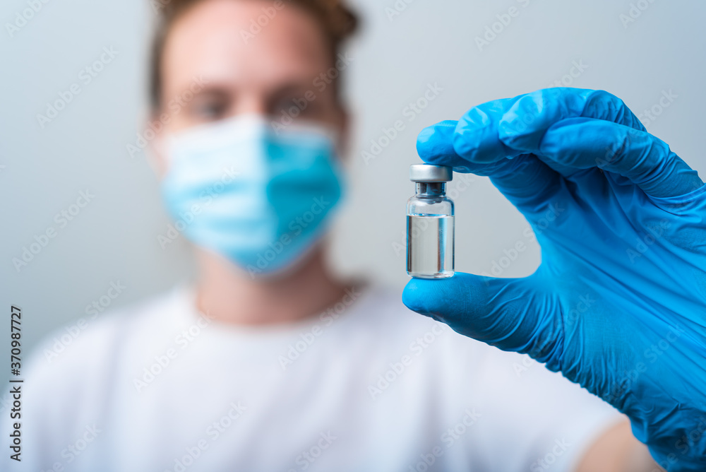 Medical worker holding flask with cure for corona-virus, cure for virus disease