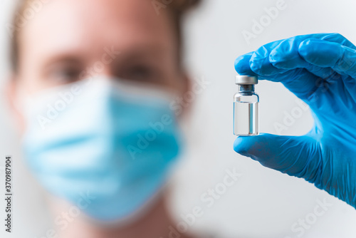 Portrait of medical worker pholding flask with Corona virus vaccine
