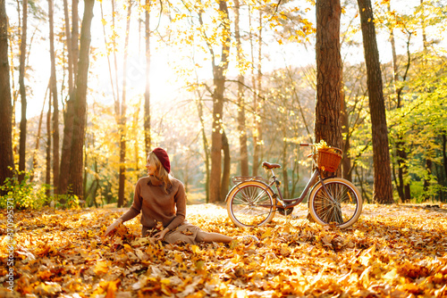 Beautiful Woman throws up autumn leaves and having fun  in autumn park. Relaxation  enjoying  solitude with nature.