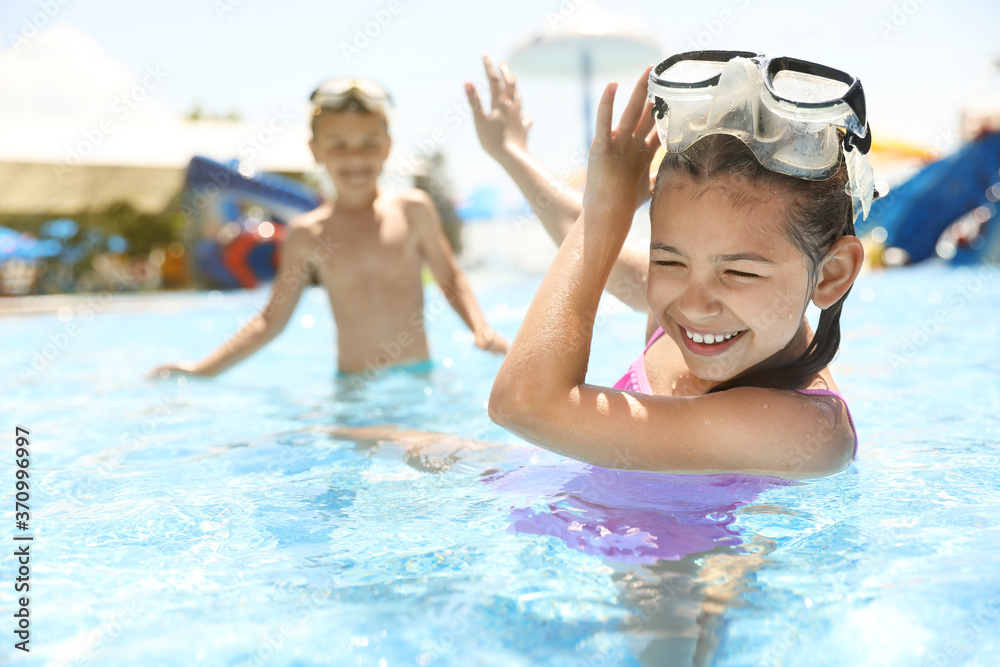 Little children having fun in swimming pool. Summer vacation