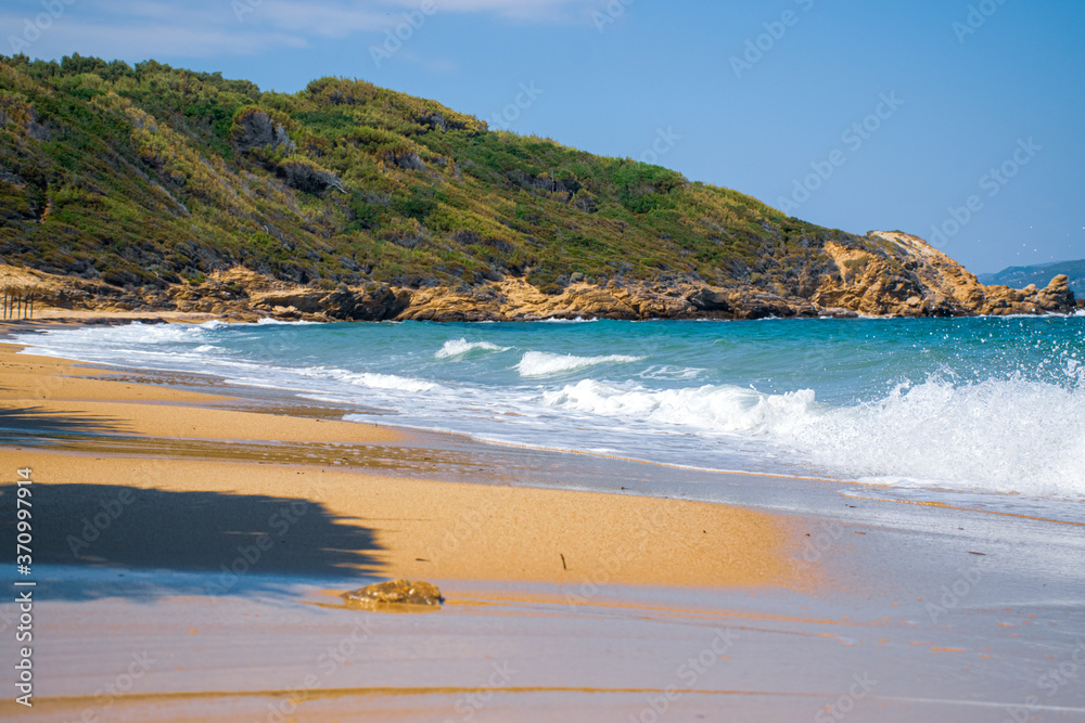 remote beach on the Mediterranean sea in Greece, with azure water and white waves