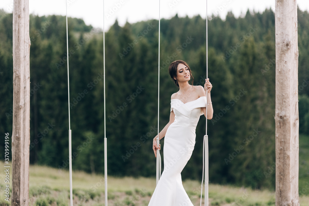 Beautiful bride with bouquet flowers stands on forest background. beautiful bride in delicate dress outdoors. Close up portrait of young bride in park in sunny weather wooded area. Beautiful bride with bouquet flowers stands on forest background. beautiful bride in delicate dress outdoors. Close up portrait of young bride in park in sunny weather wooded area.