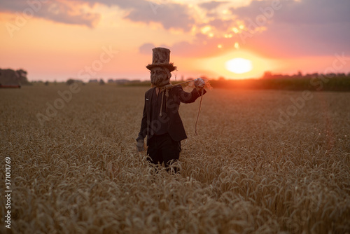 Sorcerer performs black magic ritual and portrays hanged man at sunset.