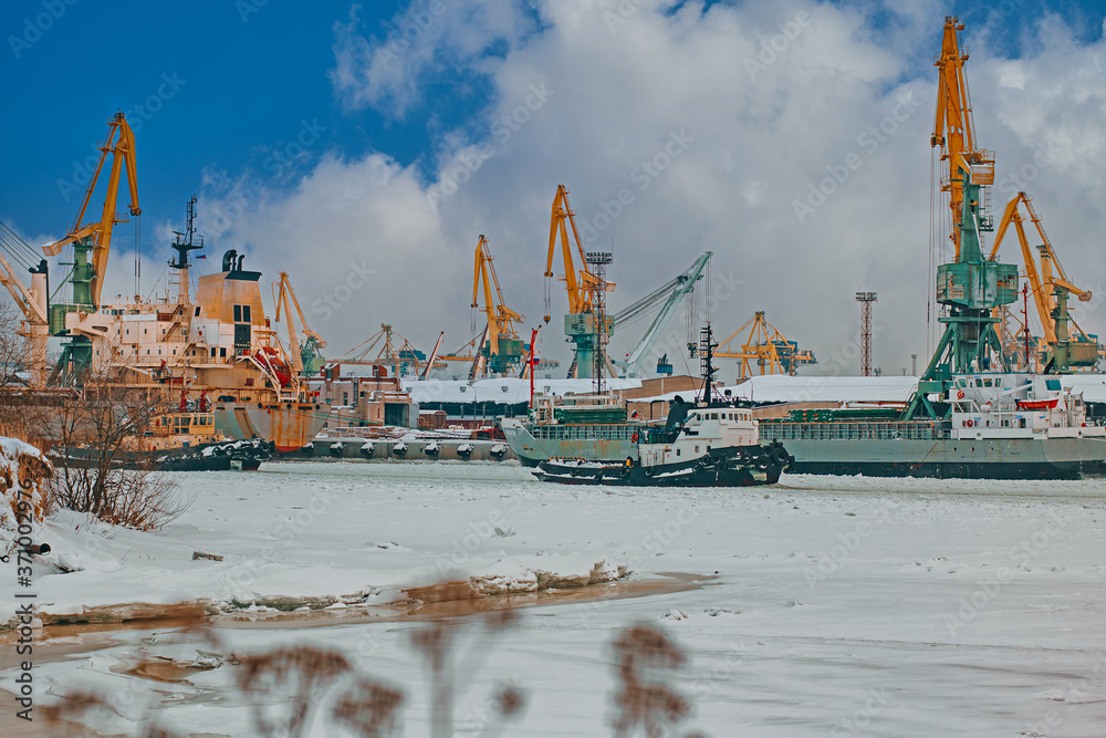 Ships and cranes at the seaport in winter. 
