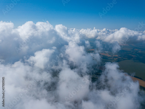 High flight in the clouds over agricultural fields. © Sergey
