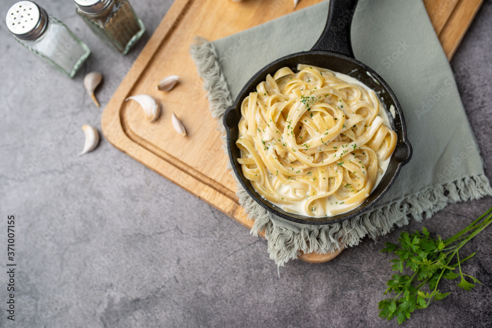 Wall Mural Alfredo pasta dinner with creamy white sauce and herbs
