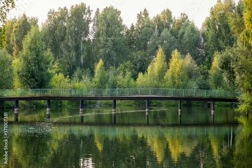Beautiful landscape on the river with a bridge with reflection during sunset. Silence and tranquility in nature, reuniting with nature, relaxation. Rural tourism and recreation concept