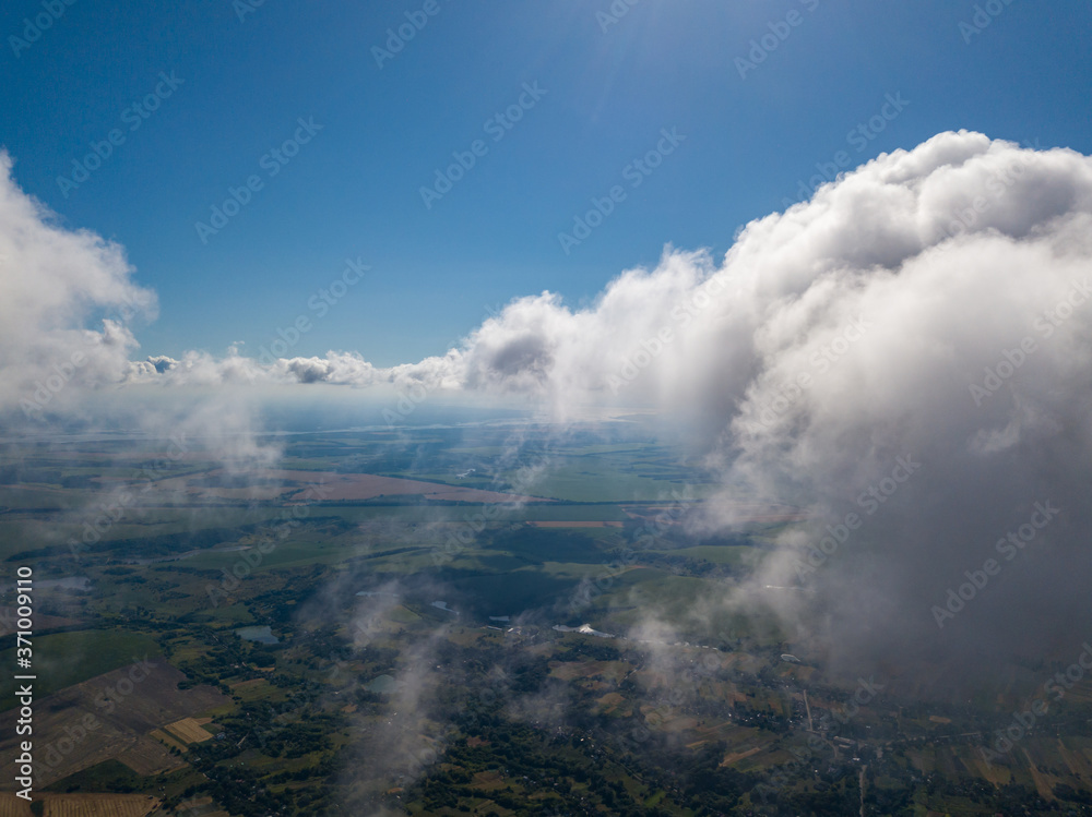 High flight in the clouds over agricultural fields.