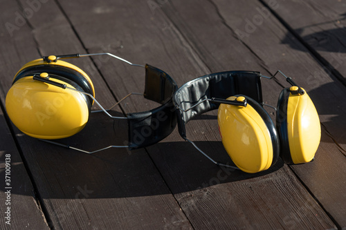 
Yellow headphones for shooting lie on a wooden table