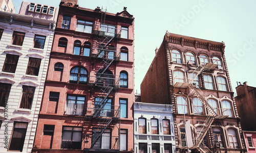 Old tenement houses with fire escapes, color toning applied, New York City, USA.