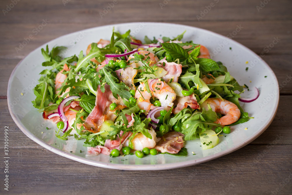 Shrimp salad with bacon, cucumber and radish on wooden background close up. Clean eating Shrimp salad with bacon, cucumber and radish on wooden background close up. Clean eating