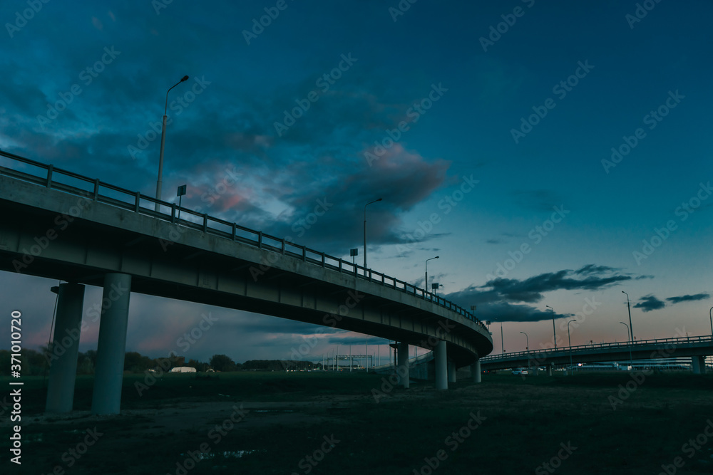 Exit from the overpass on the highway. Evening cityscape. 